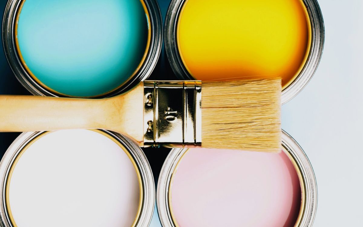 Paint cans with colorful coatings and paintbrush for industrial and decorative painting applications